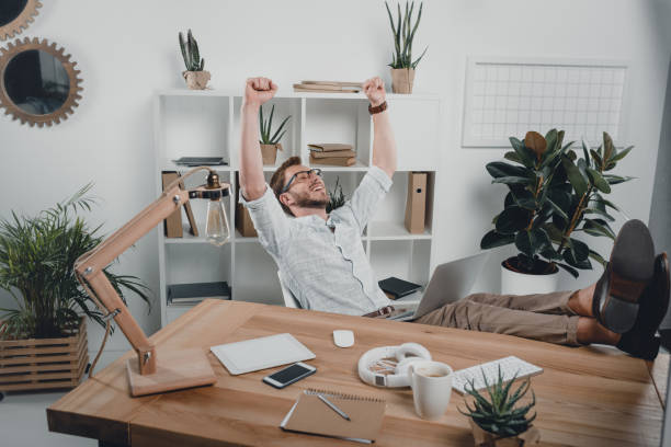 istock cheerful caucasian businessman sitting at workplace and using laptop in modern office 700126394