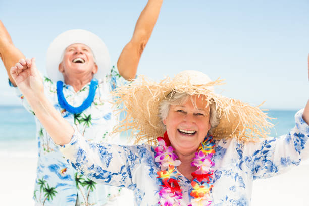 istock Senior couple with arms up on the beach 700128622