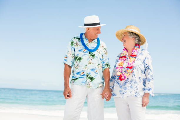 istock Senior couple holding hands on the beach 700132874