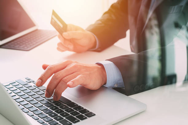 istock businessman making credit card purchase online with laptop computer on modern desk 700139302