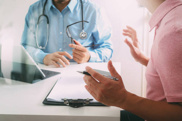 medical doctor using mobile phone and consulting businessman patient having exam as hospital professionalism concept - telephone doctor medical exam healthcare and medicine imagens e fotografias de stock