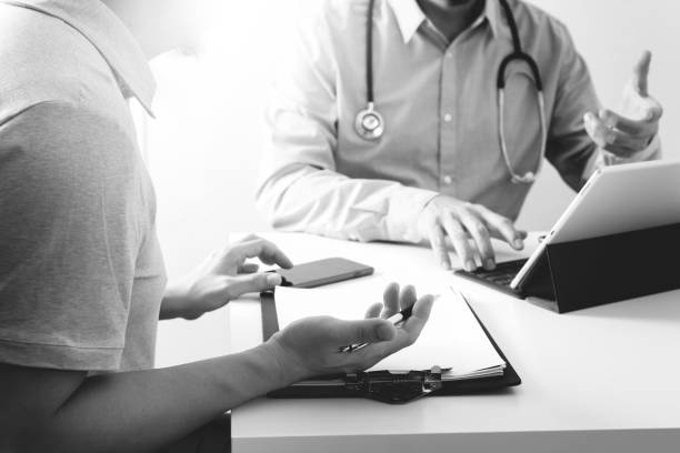 medical doctor using mobile phone and consulting businessman patient having exam as hospital professionalism concept - telephone doctor medical exam healthcare and medicine imagens e fotografias de stock