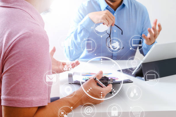 istock Businessmen working together on a document and using smart phone and digital tablet and laptop computer in modern office with VR icon diagram 700141104