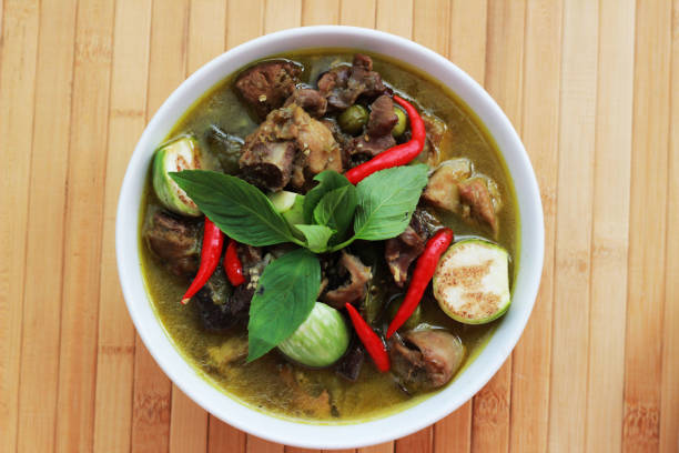 Green curry in white cup on brown bamboo floor