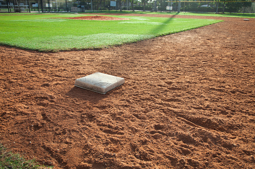 A youth baseball field infield with first base in the foreground
