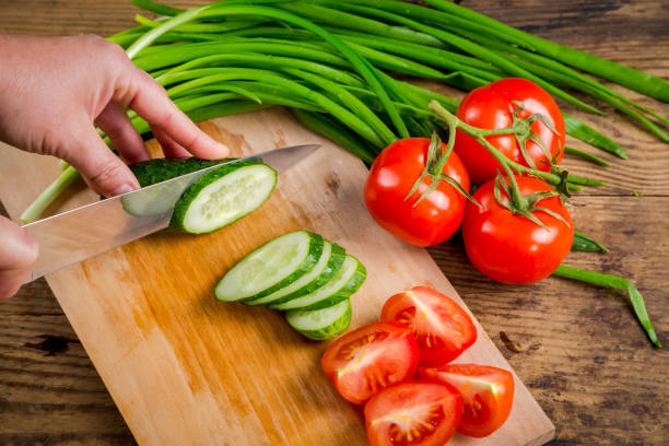 istock Cut cucumber on wooden cutting board, above view 700180668