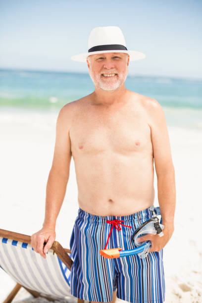 istock Senior man standing next to sunchair 700181274
