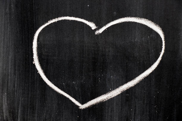 istock Chalk hand drawing as heart shape on black board background 700181610