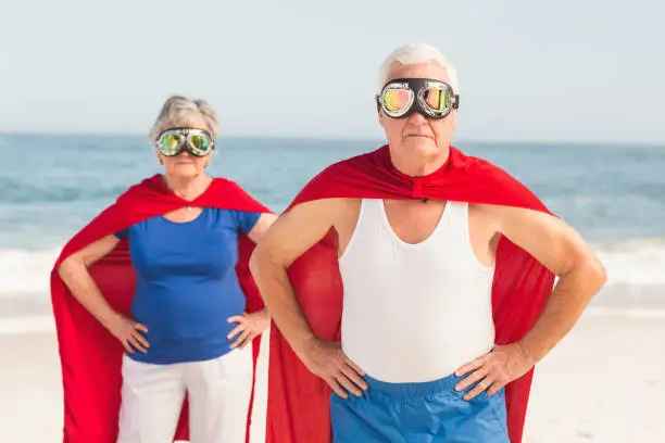 Senior coiple wearing superman costume on a sunny day