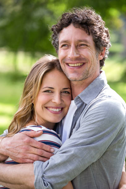 istock Smiling couple embracing in park 700184016