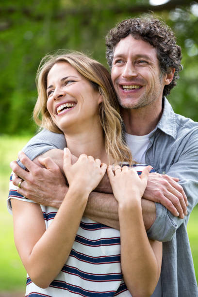 istock Smiling couple embracing in park 700184282