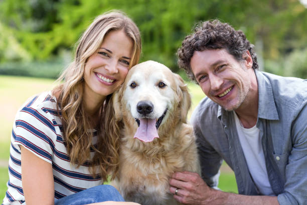 istock Smiling couple with dog in the park 700185072