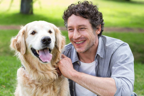 istock Smiling man with his dog in park 700185250