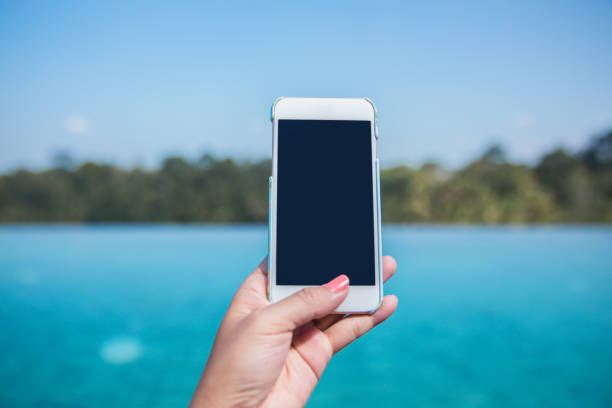 istock Young women unlocking phone with thumb fingerprint 700193458