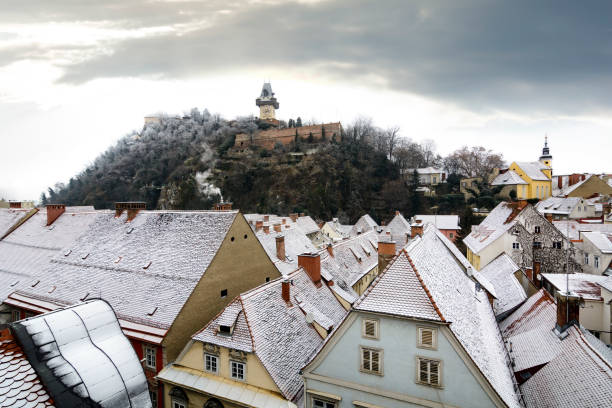 scène d’hiver avec la tour de l’horloge et les toits enneigés de graz - graz clock tower clock austria photos et images de collection