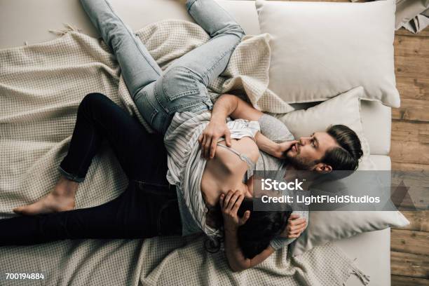横になっているとベッドの上を抱いて愛好家の官能的な若いカップルの平面図 - 真俯瞰のストックフォトや画像を多数ご用意 - 真俯瞰, カップル, 官能