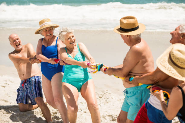 istock Seniors playing tug of war at the beach 700212246