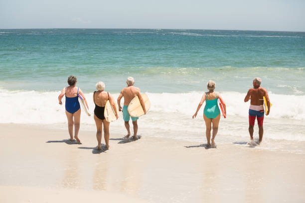 istock Seniors carrying surfboards at the beach 700212476