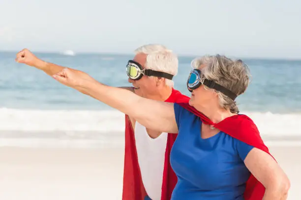 Senior couple wearing superman costume on a sunny day