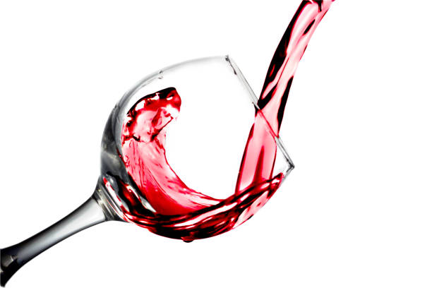 istock Red dry wine pours into a wineglass on a white background 700215328