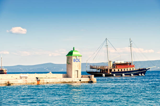 Pier of Bol in Croatia with  historic cruising  ships. The tower shows the name of the destination.