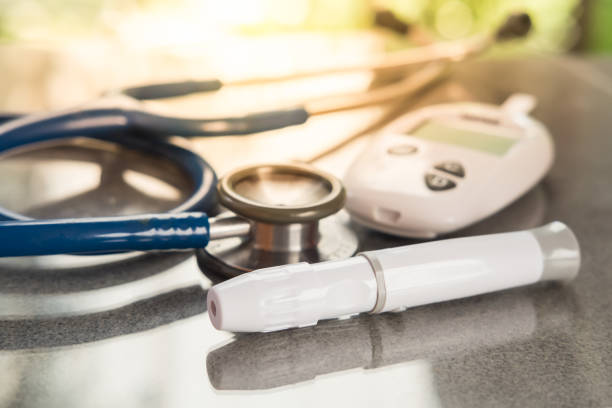 Stethoscope and blood glucose meter, lancet on the wooden table.Healthcare medical and check up, diabetes, glycemia, and people concept. Flat lay. stock photo