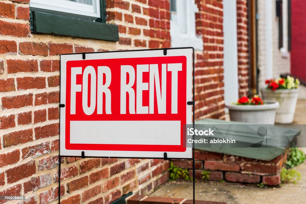 Closeup signe rouge à louer contre le bâtiment en briques - Photo de Panneau À louer - Panneau immobilier libre de droits