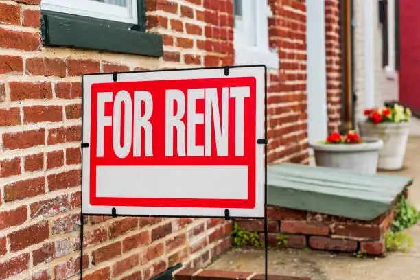 Red For Rent sign closeup against brick building