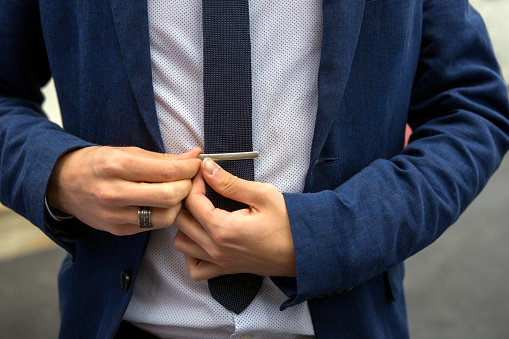Young teen boy casually dressed fixes his tie needle