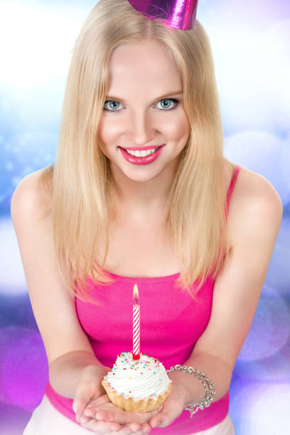 istock Young woman with birthday cupcake 700234710