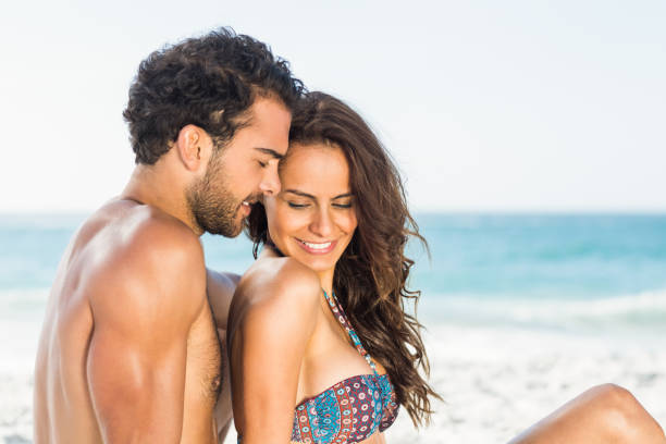 istock Happy couple sitting on the beach 700238490
