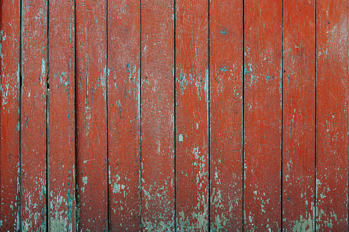 Aged peeling wooden surface painted with red paint