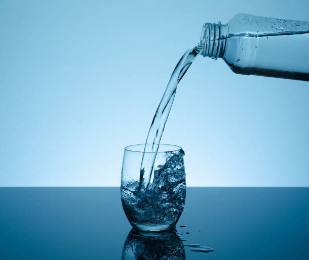 istock Bottle with creative splashing water in the glass 700241536