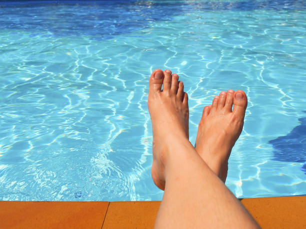 istock Woman's bare foot at swimming pool. 700250778