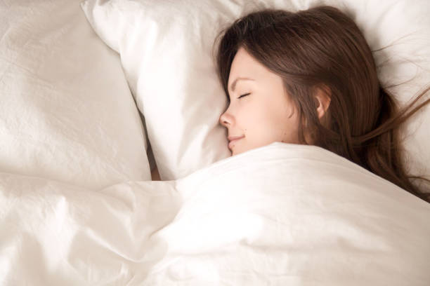 istock Young woman sleeping well under warm blanket 700250916