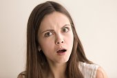 Emotive headshot portrait of shocked young woman