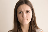Emotive headshot portrait of indecisive young woman