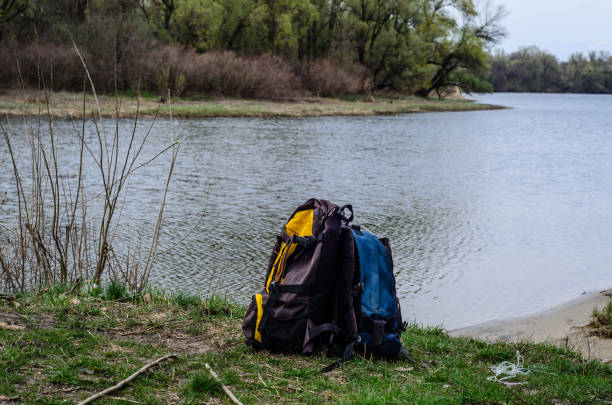 istock Backpacks on a bank of the river 700253512