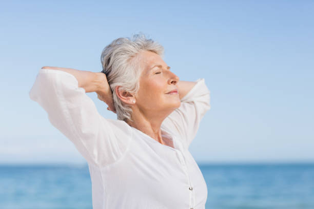 istock Senior woman relaxing on the beach 700254078