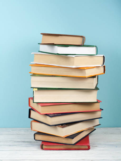 istock Open stacking book, hardback colorful books on wooden table and blue background. Back to school. Copy space for text. Education business concept 700259770