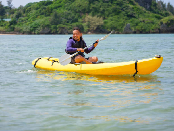 Young Japanese people enjoying an ocean kayak adventure in Okinawa, Japan.