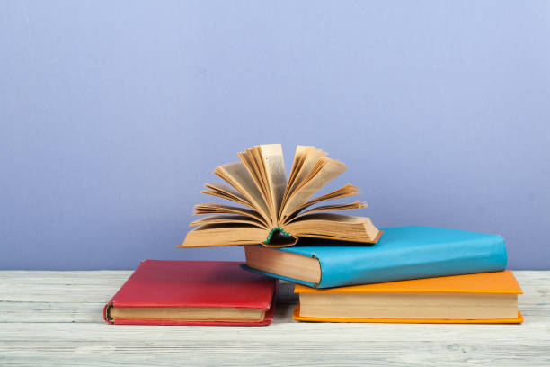 istock Open book, hardback colorful books on wooden table. Back to school. Copy space for text. Education business concept 700268022