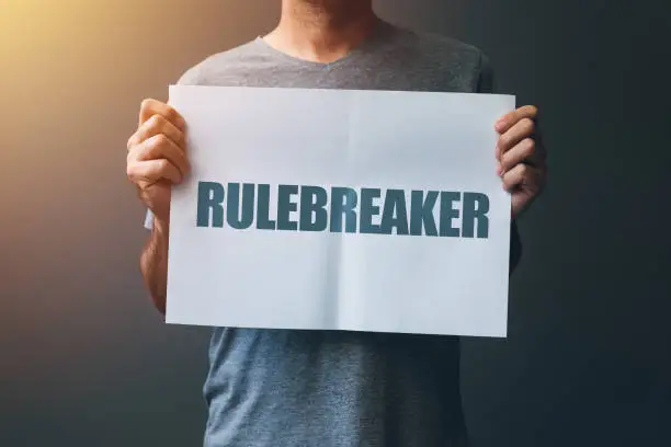 Rulebreaker attitude, person who breaks the rules concept with male holding poster