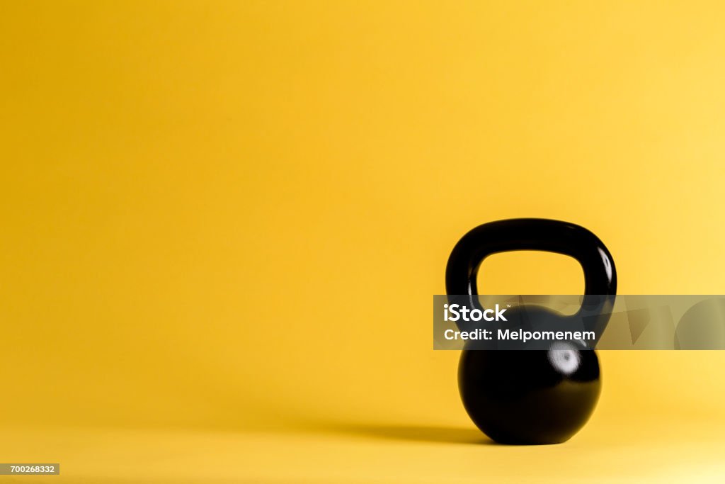 Cast iron kettlebell Cast iron kettlebell on a yellow background Kettlebell Stock Photo