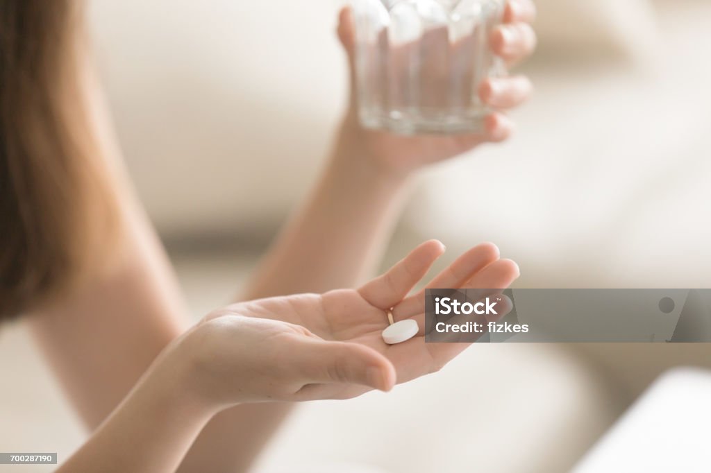 Gros plan photo de ronde pilule blanche en main féminine - Photo de Comprimés libre de droits