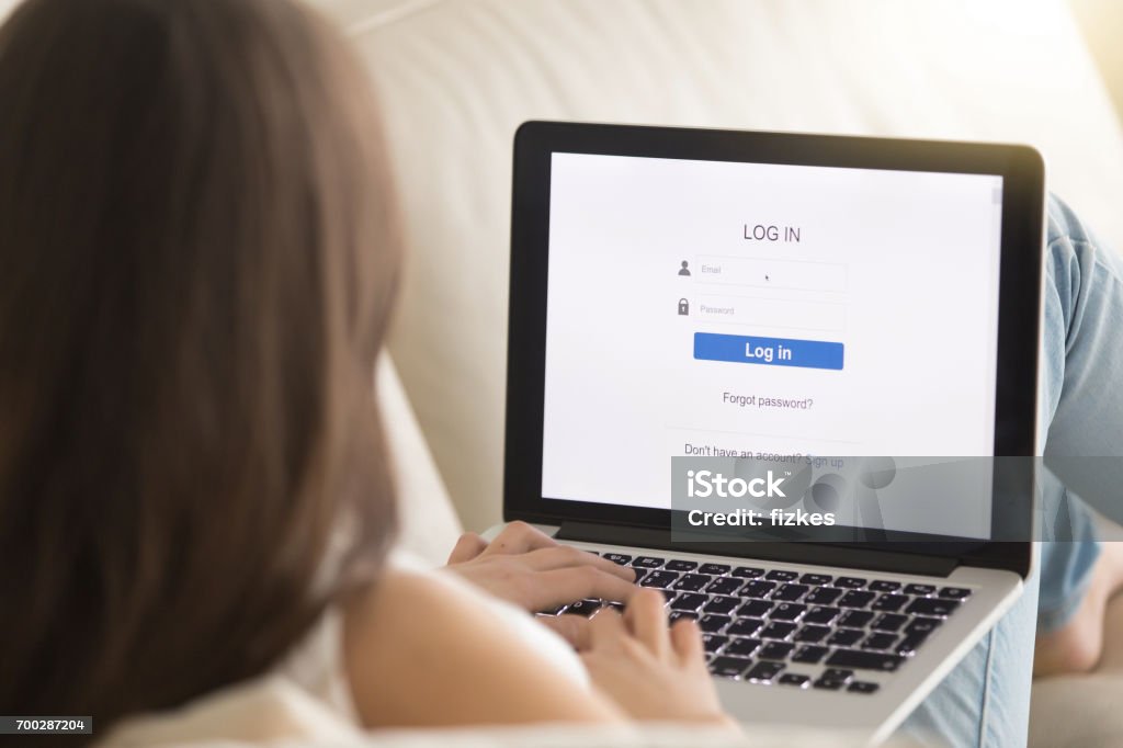 Female user passes security authorization system Woman lying on sofa with laptop enters email and password on web verification page. Female user passes security authorization system on her online banking account. Close up view over the shoulder Creativity Stock Photo