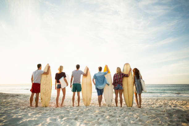 istock Friends holding surfboard on the beach 700287214