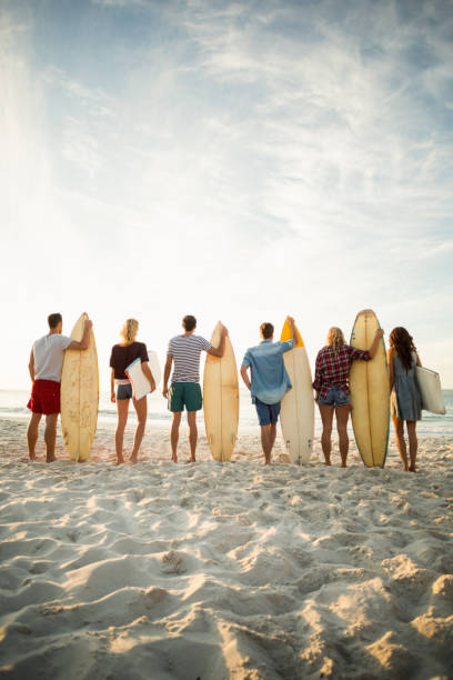 istock Friends holding surfboard on the beach 700287252
