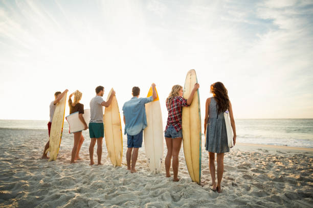 istock Friends holding surfboard on the beach 700287276