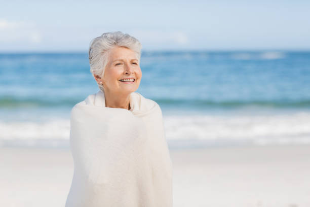 istock Senior woman relaxing on the beach 700287388